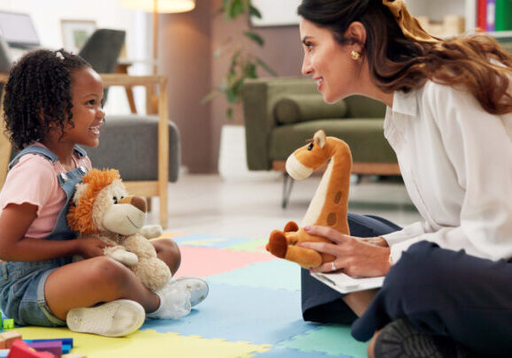 Psychology, woman and girl with dolls, talk and happy with clipboard for emotional assessment on floor. Person, therapist and child with toys, playful and checklist for test at mental health clinic