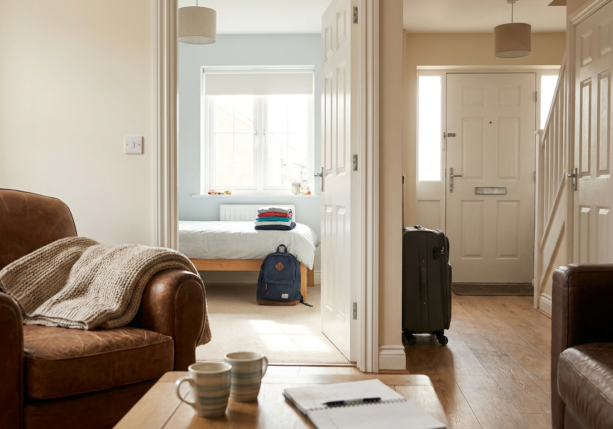 open domestic interior with suitcase, bedroom, and living area, suggesting transition or couples therapy custody issues.