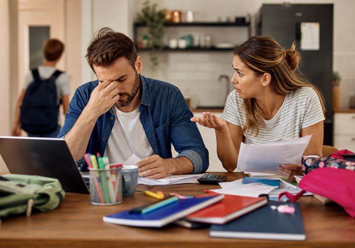 stressed couple arguing about finances and school supplies, reflecting couples therapy back-to-school stress.