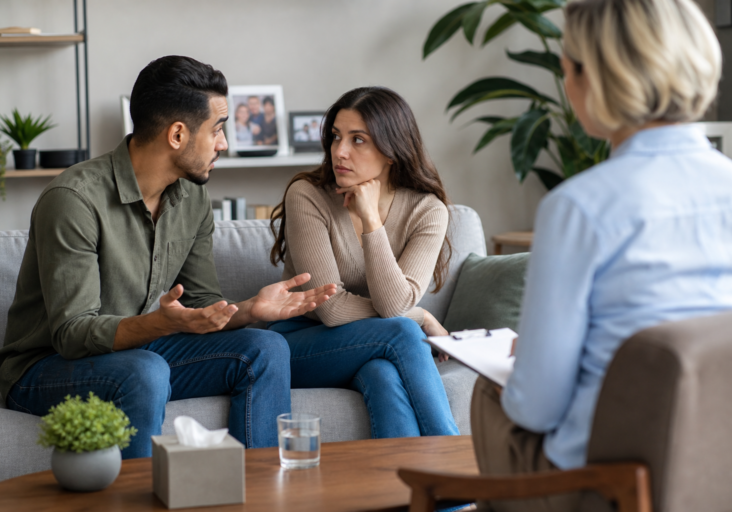 couple discussing issues during couples therapy family boundaries session with a female therapist.