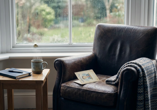 a cozy armchair with a father's day card and a notebook, perfect for fathers day therapy.