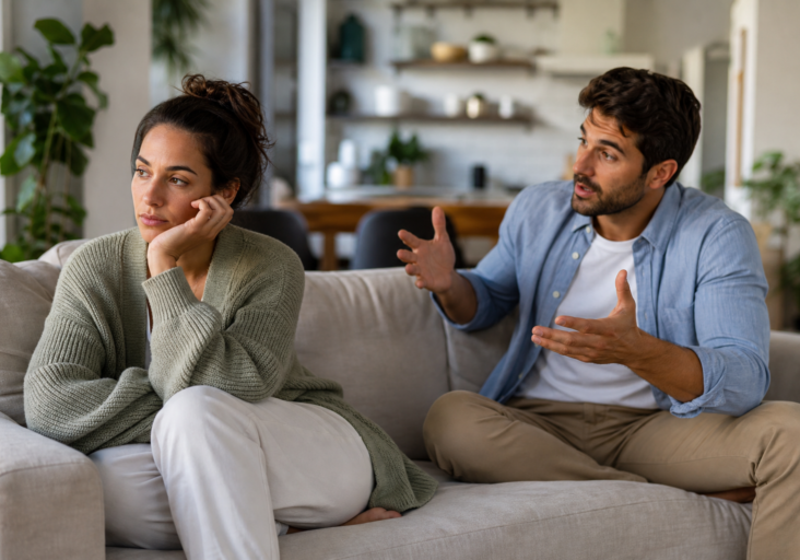 frustrated man talking to an unresponsive woman portray couples with different social needs on a sofa.